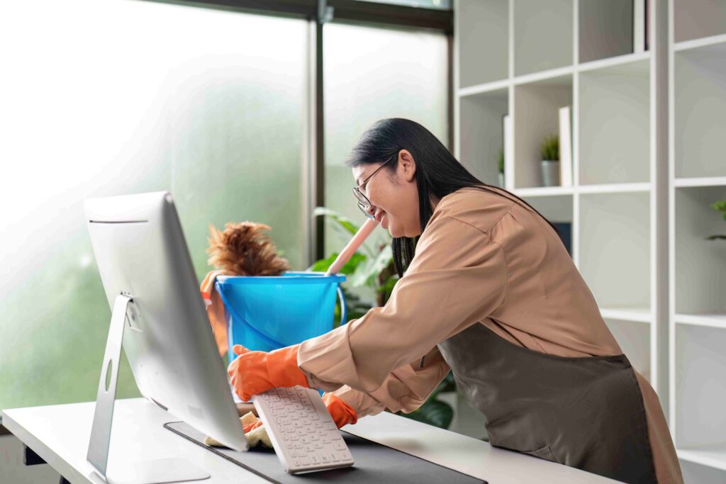 Focused Asian woman conducting thorough office cleaning routine